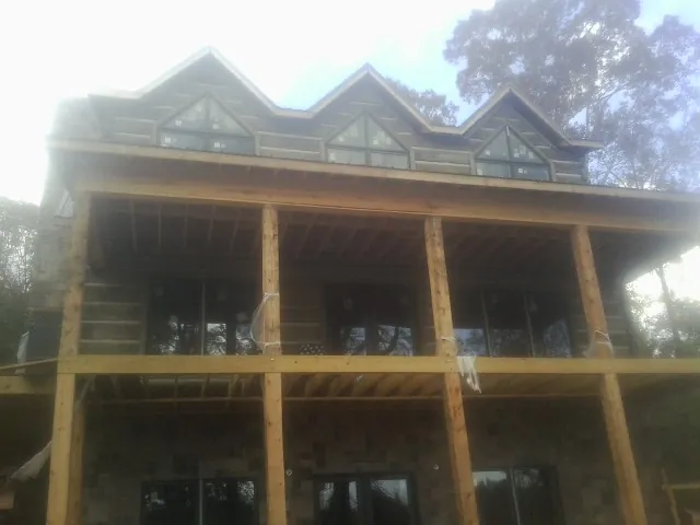 Dormers and porch framing on a large log home under construction — Roof Coating work by our crew in Fort Monmouth