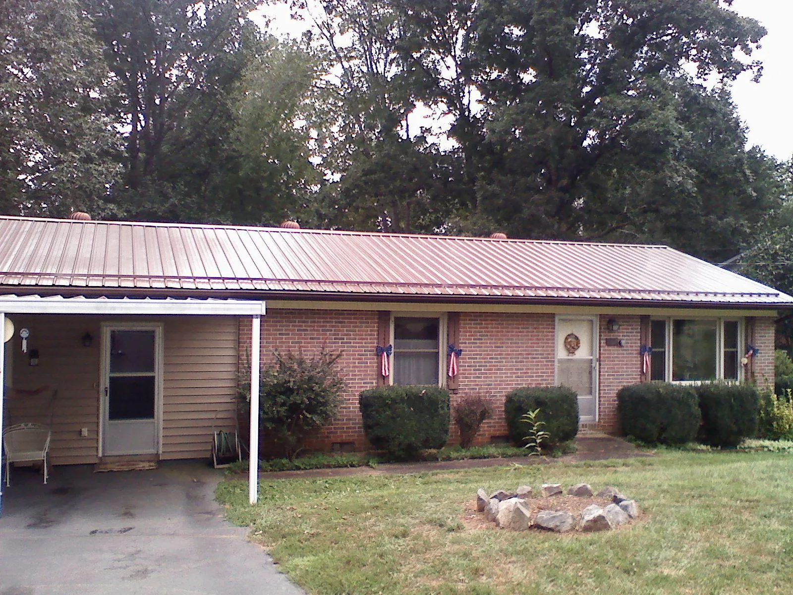 Bronze metal roof and carport on a brick ranch home — Roof Repair work by our crew in Fort Monmouth